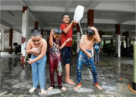  ?? — AZHAR MAHFOF/The Star ?? Sheer joy: Children enjoying a shower after the water supply returned at their apartment in Kota Damansara, Selangor.