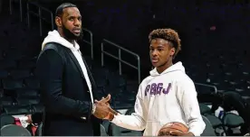  ?? KEVORK DJANSEZIAN / GETTY IMAGES ?? LeBron James with his 14-year-old son, LeBron Jr., also known as Bronny, after a Los Angeles Lakers game last year.