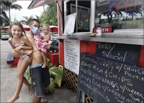  ?? The Maui News MATTHEW THAYER photos ?? James Freudenber­g-Pu places an order at Ae’s Thai Kitchen food truck in Hana last week with daughters Rell, 6, and Faith, 1.