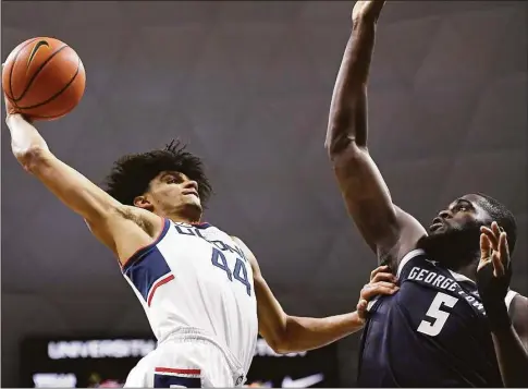  ?? Jessica Hill / Associated Press ?? UConn’s Andre Jackson winds up for a dunk as Georgetown’s Timothy Ighoefe defends in the first half on Jan. 25.