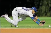  ?? [AP PHOTO] ?? Chicago’s Addison Russell can’t reach a ball hit by Los Angeles’ Chris Taylor during the fourth inning of Game 5 of the National League Championsh­ip Series on Thursday night at Wrigley Field. HOUSTON —