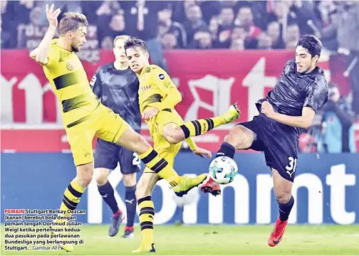  ??  ?? PEMAIN Stuttgart Berkay Oezcan (kanan) berebut bola dengan pemain tengah Dortmud Julian Weigl ketika pertemuan keduadua pasukan pada perlawanan Bundesliga yang berlangsun­g di Stuttgart. - Gambar AFP