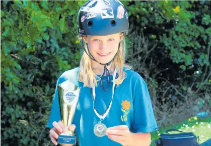  ?? Photo / Rosalie Willis ?? Alana Reardon with her trophy and medal for winning the girls’ under-14 national scooter title.