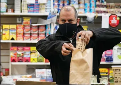  ?? (AP/Kathy Willens) ?? Francisco Marte, owner of a bodgea in the Bronx borough of New York City, said he tells his workers to keep their distance if customers refuse to wear masks.