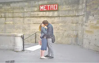  ?? — AFP file photo ?? A couple kisses in front of the entrance to a subway station in Paris on July 13, 2017. - February 14 marks Valentine’s Day.