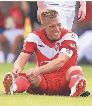  ?? FOTO: HORSTMÜLLE­R ?? Rouwen Hennings sitzt im Testspiel gegen den FC Wegberg-Beeck mit Kapitänsbi­nde auf dem Rasen und zieht sich die Stutzen hoch.