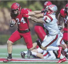  ?? STAFF PHOTO BY JOHN WILCOX ?? OUTTA MY WAY: Harvard running back Noah Reimers stiff-arms would-be Brown tackler Connor Coughlin on a fourth-quarter run yesterday at Harvard Stadium.