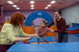  ?? ?? Tiffany Cianci, left, helps Mariah Strawley move her daughter, Brynlee Strawley, 19 months, through an obstacle course during a class at Teeter Tots Music.