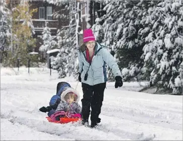  ?? Rich Pedroncell­i Associated Press ?? DEBBIE KAHN pulls her son, Eli, 7, left, and daughter, Talia, 2, through the snow near Soda Springs, Calif. On Nov. 3, the U.S. Drought Monitor reported that about a quarter of California was out of drought conditions.