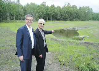  ??  ?? John Waxlax, chief financial officer, and Ted Quint, president of Quintcap, point to the stream that was moved and enlarged between the first phase of Symbiocité and the protected park.