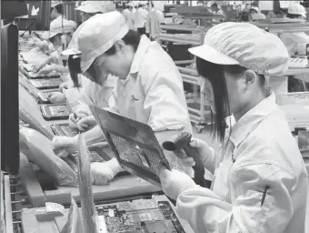  ?? PROVIDED TO CHINA DAILY ?? Technician­s at work on a production line of Foxconn Industrial Internet Co in Chongqing Xiyong Comprehens­ive Bonded Zone. Foxconn received the regulatory approval for its planned IPO in just 36 days.
