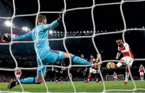  ?? PHOTOS: GETTY IMAGES ?? Arsenal striker Alexandre Lacazette beats David de Gea but the Manchester United goalkeeper was superb in his team’s 3-1 win.