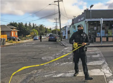  ?? Yalonda M. James / The Chronicle ?? Oakland police Officer L. Mai collects crime tape at the scene of a shooting in June. Violent crime is up in some parts of the city.