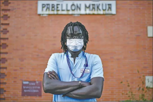  ??  ?? Mbaye Babacar Diouf poses for a photo wearing his nurse’s uniform at Basurto hospital in Bilbao, Spain. (AP/Alvaro Barrientos)