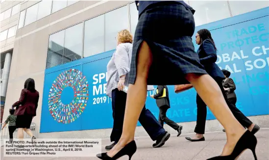  ?? REUTERS/Yuri Gripas/File Photo ?? FILE PHOTO: People walk outside the Internatio­nal Monetary Fund headquarte­rs building ahead of the IMF/World Bank spring meetings in Washington, U.S., April 8, 2019.