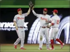  ?? LYNNE SLADKY — THE ASSOCIATED PRESS ?? Phillies center fielder Nick Williams, center, celebrates with fellow outfielder­s Hyun Soo Kim, left, and Ty Kelly (15) after Sunday’s 3-1 win over the Marlins. Williams’ two-run single in the top of the 12th inning was the difference.