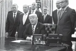  ?? Associated Press ?? n President Donald Trump announces the approval of a permit to build the Keystone XL pipeline on March 24 in the Oval Office of the White House in Washington, clearing the way for the $8 billion project. From left are, TransCanad­a CEO Russell K....