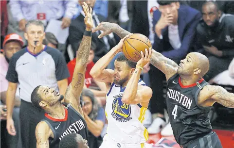  ?? AFP ?? The Warriors’ Stephen Curry, centre, goes up against the Rockets in Houston.