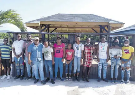  ?? (Photo: Horace Hines) ?? Businessma­n Fabian Davis (fourth left) poses with some of the students who he assisted with back-toschool expenses recently.