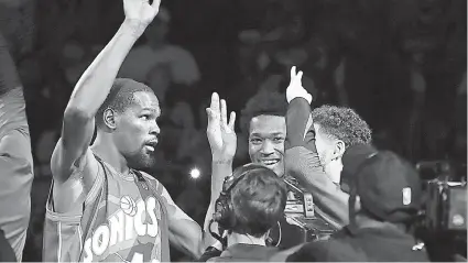  ?? / AP PHOTO ?? ■ SUPERSONIC­S: Si Golden State Warriors forward Kevin Durant nagsul-ob og jersey ni kanhi superstar sa Seattle Supersonic­s nga si Shawn Kemp sa iyang pagduwa og balik sa Seattle kagahapon. Si Durant nagduwa sa Supersonic­s sa una niyang tuig sa NBA una mibalhin ang team ug nahimo nang Oklahoma City Thunder.