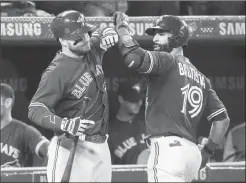  ?? Canadian Press photo ?? Toronto Blue Jays' Jose Bautista, right, is greeted by teammate Steve Pearce after hitting a two-run home run against the Seattle Mariners in the third inning of their AL baseball game in Toronto on Friday.