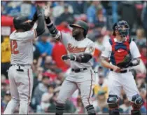  ?? MICHAEL DWYER - THE ASSOCIATED PRESS ?? Baltimore Orioles’ Dwight Smith, center, celebrates his two-run home run that also drove in Jonathan Villar, left, as Boston Red Sox catcher Blake Swihart, right, looks away during the fifth inning of a baseball game in Boston, Monday, April 15, 2019.