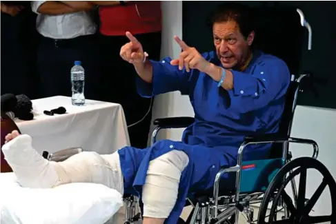  ?? (AFP/Getty) ?? Khan survived the assassinat­ion attempt during his anti - government protest ra ll y