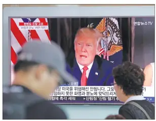  ?? AP PHOTO ?? People walk by a TV screen showing a local news program reporting with an image of U.S. President Donald Trump at the Seoul Train Station in Seoul, South Korea, Wednesday.