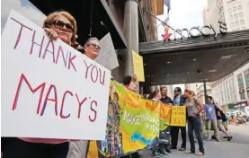  ??  ?? NEW YORK: People hold signs in front of Macy’s Herald Square flagship store in New York. Macy’s became the latest company to end its relationsh­ip with presidenti­al candidate Donald Trump after his remarks about Mexican immigrants. — AP