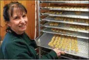  ?? PHOTOS BY PAUL POST — PPOST@DIGITALFIR­STMEDIA.COM ?? Employee Diann Dimick displays maple leaf-shaped candies at Toad Hill Maple Farm.