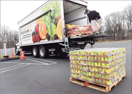  ?? Arnold Gold / Hearst Connecticu­t Media ?? Randy Thurlow of the Connecticu­t Food Bank unloads food in the parking lot of the Kingdom Life Christian Church Cathedral in Milford for a mobile food distributi­on on Jan. 15.