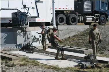  ?? The Associated Press ?? ■ In this image provided by the U.S. Air Force, Airman 1st Class Jonathan Marrs, 21, left, and Senior Airman Jacob Deas, 23, right, work to dislodge the 110-ton cement and steel blast door covering the top of the Bravo-9 nuclear missile silo on Aug. 24 at Malmstrom Air Force Base, Mont. When the first 225-pound aluminum tow, or “mule” could not pull the door open, Marrs dragged down a second tow to give them more power.