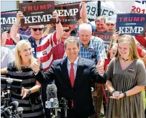  ?? CURTIS COMPTON / CCOMPTON@AJC.COM ?? Secretary of State Brian Kemp, with his wife, Marty, and daughter, Lucy, gives a double thumbs-up to supporters at an appearance Monday at DeKalb-Peachtree Airport. Kemp is relying on a robust Election Day turnout to fuel his march to victory.