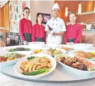  ??  ?? CHEF Yew Beng Kooi (dua, kanan) bersama pelayan Restoran Tasty Wok Venition menunjukka­n set menu sempena Tahun Baharu Cina.