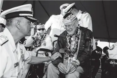  ?? Photos by Kat Wade / Getty Images ?? Navy Rear Adm. Darius Banaji, left, greets Pearl Harbor survivor Tom Berg, 97, on the attack’s 78th anniversar­y Saturday at the Pearl Harbor National Memorial in Honolulu.
