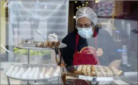  ?? MARCIO JOSE SANCHEZ — THE ASSOCIATED PRESS FILE ?? A worker prepares desserts at the Universal City Walk, in Universal City, Calif. Easing of pandemic restrictio­ns has fueled service industry recovery as more people flock to bars, restaurant­s and other venues.