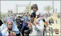  ?? REUTERS ?? A displaced Sunni man fleeing the violence in Ramadi carries a crying child on his shoulders, on the outskirts of Baghdad, on Sunday.