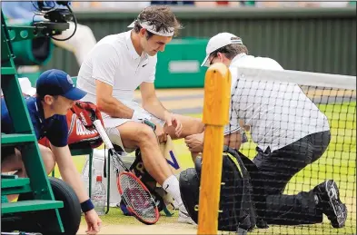  ?? AP FILE ?? Roger Federer receives medical attention during a match at Wimbledon in July. A knee injury kept Federer out of the Olympics and will cause him to miss the U.S. Open.