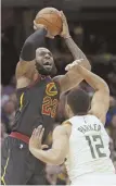  ?? AP FILE PHOTO ?? CARRY ON: LeBron James shoots over Milwaukee’s Jabari Parker last night in Cleveland’s first game without coach Tyronn Lue.