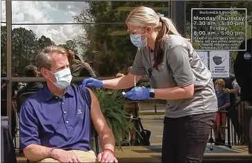  ?? WSB-TV ?? Gov. Brian Kemp gets the Johnson & Johnson vaccine March 26 at the Ware County Health Department in Waycross. His youngest daughter also got the shot. He said he chose that vaccine in part because he wanted one shot.