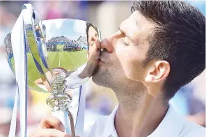  ??  ?? Serbia’s Novak Djokovic kisses the trophy after victory over France’s Gael Monfils during the men’s final tennis match at the ATP Aegon Internatio­nal tennis tournament in Eastbourne, southern England, on July 1, 2017. Serbia’s Novak Djokovic beat...