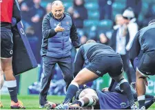  ??  ?? England head coach Eddie Jones speaks to players during their warm-up prior to the game against France at Twickenham