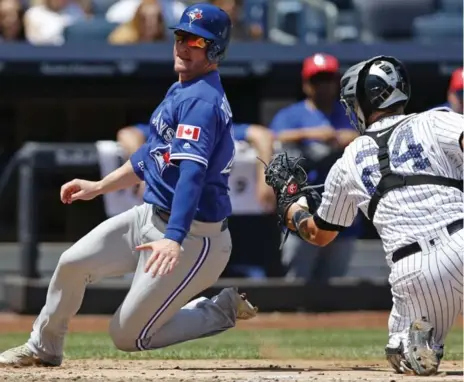  ?? KATHY WILLENS/THE ASSOCIATED PRESS ?? The Jays’ Josh Donaldson, left, scores past the late tag of Yankees catcher Gary Sanchez during action Tuesday at Yankee Stadium.