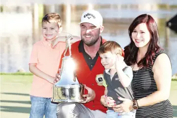  ??  ?? Marc Leishman of Australia celebrates with wife Audrey and children Oliver and Harry after finishing on the 18th green during the final round of the Arnold Palmer Invitation­al Presented By MasterCard at Bay Hill Club and Lodge in Orlando, Florida. -...