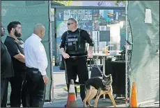  ?? RED HUBER/THE ASSOCIATRE­D PRESS ?? Orlando Police K-9 officers complete a security sweep before the onePULSE Foundation unveiled the Pulse nightclub’s interim memorial in May, in Orlando, Fla., a temporary tribute to the victims and survivors of the 2016 mass shooting.