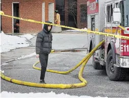  ?? JOHN RENNISON THE HAMILTON SPECTATOR ?? A student leaves Bates Residence at McMaster University during a fire Saturday. There were no injuries and the flames were quickly extinguish­ed.