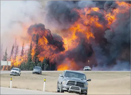  ?? — THE CANADIAN PRESS ?? A giant fireball is seen as a wildfire rips through the forest 16 kilometres south of Fort McMurray on Highway 63, the main route connecting the city to the south, on Saturday.