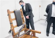  ?? STEVE HELBER/AP ?? Gov. Ralph Northam looks at Virginia’s electric chair before signing bills ending the death penalty.