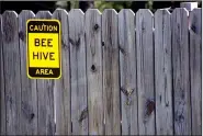  ??  ?? Visitors at Two Rivers Park get fair warning at the Cooperativ­e Extension Service’s bee research station. Scientist Jon Zawislak suggests light-colored clothing is best when working around bees. Dark clothes make bees think a human is a bear, he says.