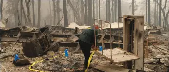  ?? (Stephen Lam/Reuters) ?? A SHERIFF in Butte County places yellow tape at the scene where human remains were found in a house burned in the Camp Fire earlier this month.